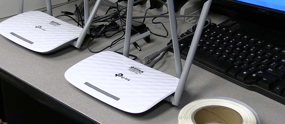 Two TP-Link routers sitting on a desk.